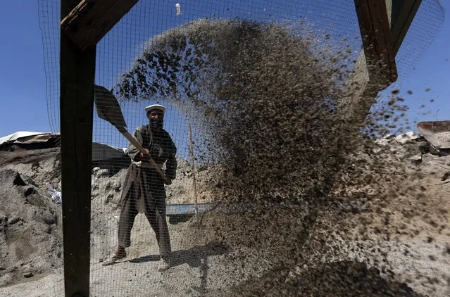 An Afghan laborer sifts construction gravel to sell, on the outskirts of Kabul, Afghanistan, Tuesday, August 9, 2016. (Photo by Rahmat Gul/AP Photo)