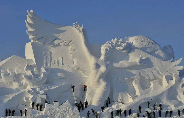 Workers carve the main sculpture 'Snow Song Winter Olympics' for the 30th Harbin Sun Island international Snow Sculpture Art Exposition on December 12, 2017 in Harbin, China.The 30th Harbin Sun Island International Snow Sculpture Art Exposition runs from December 20, 2017 – February 28, 2018. (Photo by Tao Zhang/Getty Images)