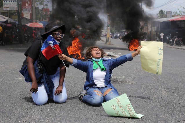 A demonstrator gestures while holding a Haiti's flag and a placard reading “No to insecurity” during a protest against gang-related violence and to demand the resignation of Haiti's transitional presidential council, in Port-au-Prince, Haiti, on March 26, 2025. (Photo by Jean Feguens Regala/Reuters)