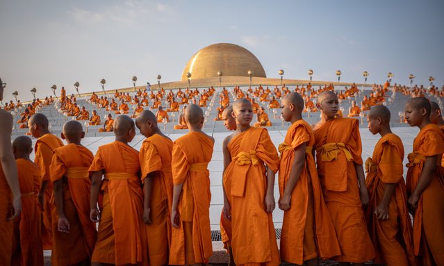Young monks gather during the yearly ceremony of Makha Bucha at Wat Dhammakaya in the north of Bangkok, Thailand on February 24, 2024. Thai people celebrate the Buddhist festival of clockwise circumambulation and Makha Bucha lantern lighting ceremony at Dhammakaya Temple on “Makha Bucha Day” during the third lunar moon, where around 5000 monks gathered to be ordained by the Buddha and 35000 devotees holding lanterns. (Photo by Guillaume Payen/Anadolu via Getty Images)