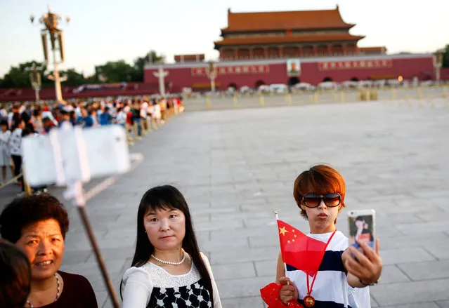 People take pictures on Tiananmen Square as the portrait of China's late Chairman Mao Zedong is seen in the background in Beijing, China, on the 40th anniversary of his death September 9, 2016. (Photo by Thomas Peter/Reuters)