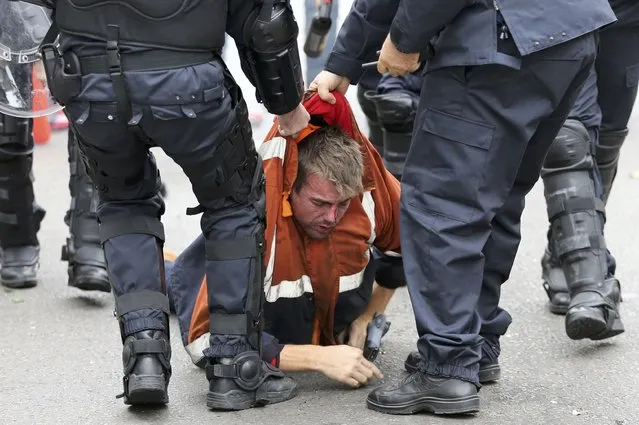 A demonstrator is restrained by riot police during clashes in central Brussels November 6, 2014. (Photo by Yves Herman/Reuters)