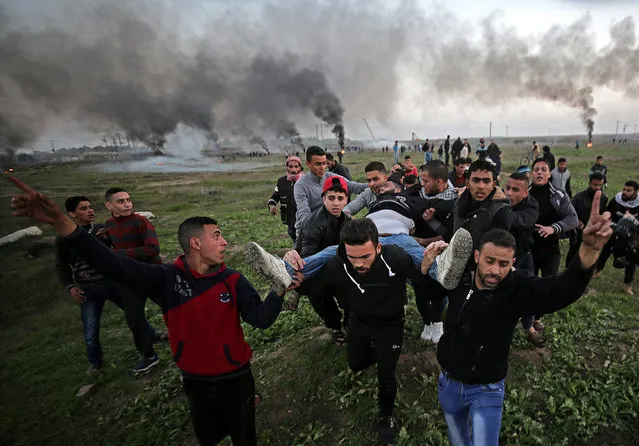Palestinian protesters carry a wounded young man during clashes between Israeli troops and Palestinians near the border in eastern Gaza City, 12 January 2018. More than forty Palestinians protesters were injured during the clashes east of Gaza Strip. (Photo by Mohammed Saber/EPA/EFE)