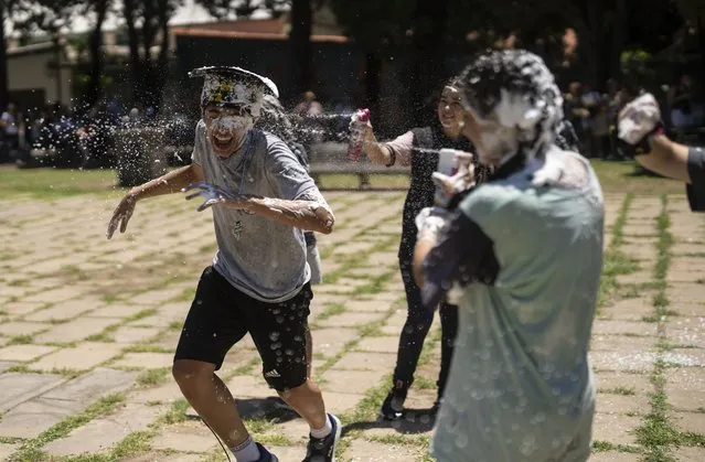 Students graduating from the General Las Heras elementary school, where soccer player Lionel Messi also attended, play with foam on their last day in Rosario, Argentina, Wednesday, December 14, 2022. (Photo by Rodrigo Abd/AP Photo)