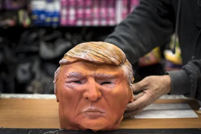 Store employee Kenny Lomi displays a Halloween mask of Republican presidential candidate Donald Trump to be photographed at the Village Party Store halloween headquarters in the Manhattan borough of New York, October 15, 2015. (Photo by Andrew Kelly/Reuters)