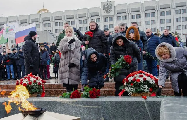 Participants lay flowers near the Eternal Flame memorial as they gather in Glory Square the day after Russia's Defence Ministry stated that 63 Russian servicemen were killed in a Ukrainian missile strike on their temporary accommodation in Makiivka (Makeyevka) in the Russian-controlled part of Ukraine, as people attend a ceremony in memory of Russian soldiers killed in the course of Russia-Ukraine military conflict, in Samara, Russia on January 3, 2023. (Photo by Albert Dzen/Reuters)