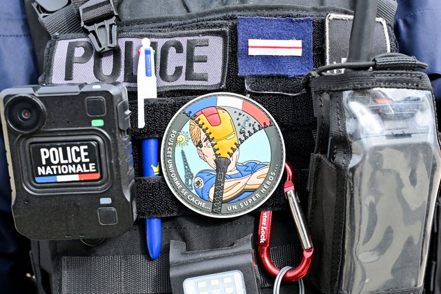 A police officer wears a logo which reads as “Under this uniform hides a superhero”, as he participates in a security operation in the Blosne district in the south of Rennes, northwestern France on March 19, 2024. A night-time shoot-out using automatic weapons took place for an hour in this district ten days ago. (Photo by Damien Meyer/AFP Photo)