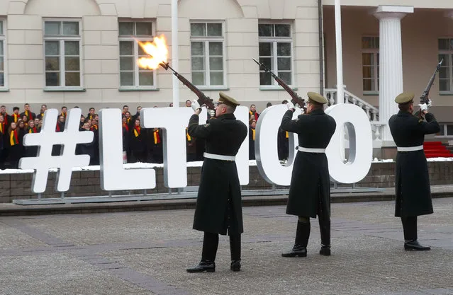 Honour guards fire their weapons during a flag-raising ceremony next to the Presidential palace during the country's centenary celebration in Vilnius, Lithuania February 16, 2018. (Photo by Ints Kalnins/Reuters)