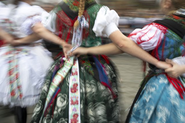 Women wearing traditional costumes perform a folk dance during a traditional Easter Monday celebration in Holloko, Hungary, April 1, 2024. (Photo by Denes Erdos/AP Photo)