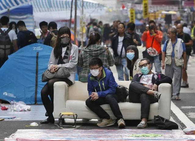 Protesters sit on a sofa before police clear the protest in Mong Kok district of Hong Kong Wednesday, November 26, 2014. Hong Kong authorities cleared street barricades from the pro-democracy protest camp in the volatile Mong Kok district for a second day Wednesday after a night of clashes in which police arrested 116 people. (Photo by Kin Cheung/AP Photo)