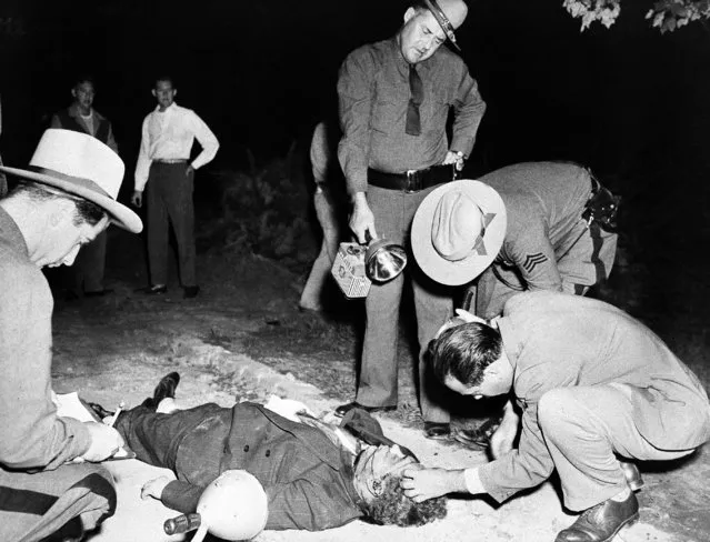 The bullet-riddled body of a man identified by police as Phil “Little Farvel” Cohen, 43, former member of Brooklyn's Murder, Inc., is inspected by state troopers and a medical examiner at Valley Stream, New York, September 15, 1949. Police said there was little question that Cohen's slaying was linked to gangland vengeance. It was Cohen's testimony that helped send Louis “Lepke” Buchalter and two others to the electric chair. (Photo by AP Photo)