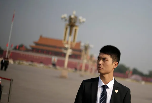 A member of the security personnel keeps watch during a tribute ceremony in front of the Monument to the People's Heroes at Tiananmen Square, ahead of National Day marking the 67th anniversary of the founding of the People's Republic of China in Beijing, China, September 30, 2016. (Photo by Jason Lee/Reuters)