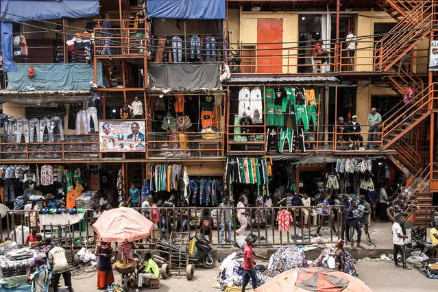 People sell clothes in a market street along Lagos island in Lagos on February 18, 2023, ahead of the Nigerian presidential election scheduled for February 25, 2023. (Photo by John Wessels/AFP Photo)