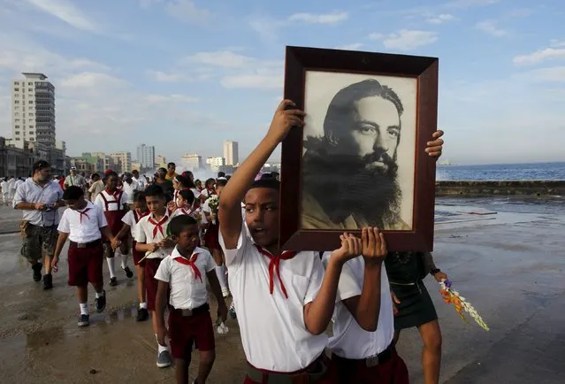 A student carries a picture of the rebel hero Camilo Cienfuegos during a gathering in honour of Cienfuegos at Havana's seafront wall "El Malecon", October 28, 2015. Cienfuegos was a commander of Fidel Castro's rebel army but died less than a year after their victory when his plane disappeared over the ocean on October 28, 1959 enroute from Havana to Camaguey. (Photo by Reuters/Stringer)