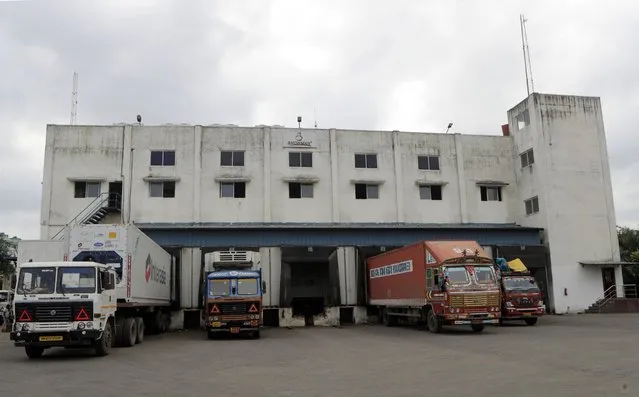 Trucks parked outside Snowman Logistics, India's largest cold storage company in Taloja, outskirts of Mumbai, India, Saturday, October 17, 2020. The vaccine cold chain hurdle is just the latest disparity of the pandemic weighted against the poor, who more often live and work in crowded conditions that allow the virus to spread, have little access to medical oxygen vital to COVID-19 treatment, and whose health systems lack labs, supplies or technicians to carry out large-scale testing. (Photo by Rajanish Kakade/AP Photo)
