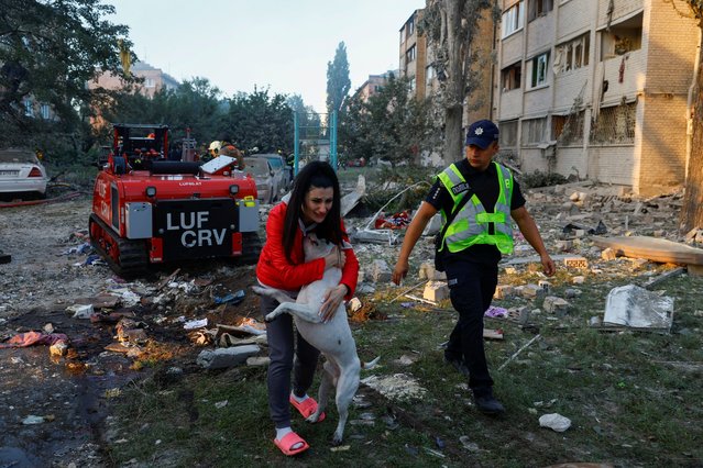 A woman reacts after reuniting with her dog at the site of a building which was hit by Russian missile and drone strikes, amid Russia's attack on Ukraine, in Kyiv, Ukraine on August 28, 2025. (Photo by Valentyn Ogirenko/Reuters)