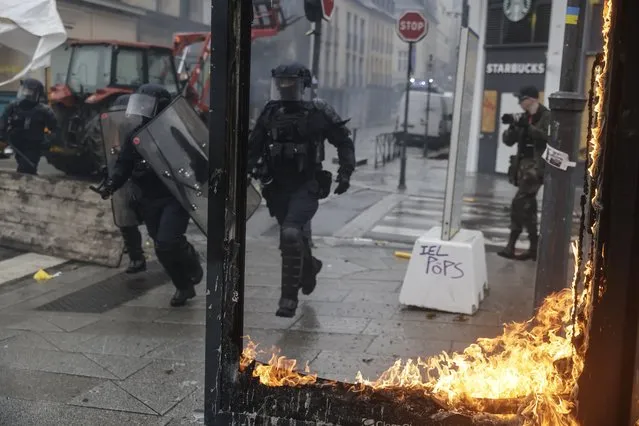 Riot police scuffle with protesters during a protest in Rennes, western France, Wednesday, March 22, 2023. The bill pushed through by President Emmanuel Macron without lawmakers' approval still faces a review by the Constitutional Council before it can be signed into law. Meanwhile, oil shipments in the country were disrupted amid strikes at several refineries in western and southern France. (Photo by Jeremias Gonzalez/AP Photo)