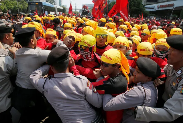 Workers push police officers to brake the barricade during a Mayday rally at business district in Jakarta, Indonesia on May 1, 2018. (Photo by Reuters/Beawiharta)