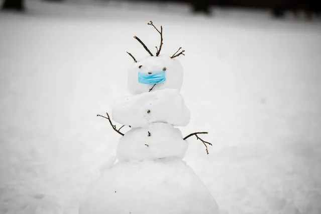 A snowman wears a face mask in Central Park on December 20, 2020 in New York City. The coronavirus pandemic has caused long-term repercussions throughout the tourism and entertainment industries, including temporary and permanent closures of historic and iconic venues, costing the city and businesses billions in revenue. (Photo by Noam Galai/Getty Images)