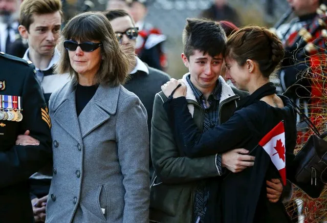 The mother, Valerie Carder (L), and sisters Lily (C) and Erin, of John Gallagher, a Canadian volunteer fighter and former Canadian forces member who was killed fighting alongside Kurdish forces in Syria against the Islamic State, react after pallbearers carried his casket into a funeral home in Blenheim, Ontario, Canada November 20, 2015. (Photo by Mark Blinch/Reuters)