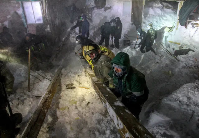 Russian Emergency ministry rescuers work at the avalanche site in the town of Talnakh, 25 kilometres (16 miles) north of Norilsk on January 9, 2021. Three people were killed after an avalanche swept through a ski resort outside the Arctic city of Norilsk overnight, Russian investigators said on January 9, 2020. The Investigative Committee, which probes major crimes, said it was notified at 00:30 local time (1730 GMT) that an avalanche had buried four buildings under snow at the Otdelnaya Gora ski complex in the town of Talnakh, 25 kilometres (16 miles) north of Norilsk. (Photo by Irina Yarinskaya/AFP Photo)
