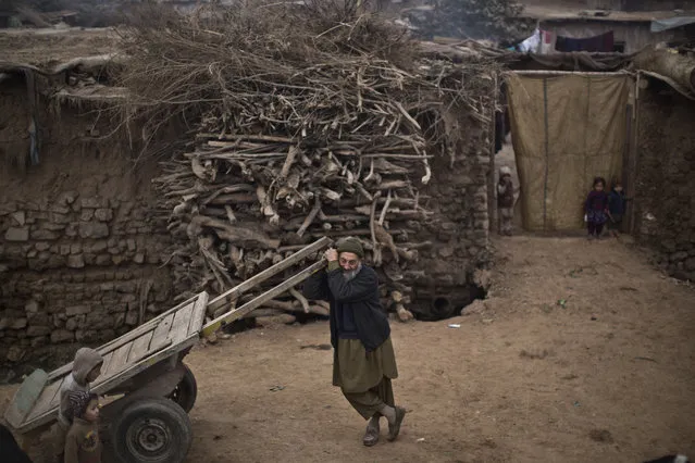 An elderly internally displaced Pakistani man from tribal areas stands in front of his mud home, waiting other men to head to work on the outskirts of Islamabad, Pakistan, Wednesday, January 7, 2015. (Photo by Muhammed Muheisen/AP Photo)