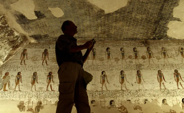 In a Thursday, November 22, 2012 file photo, a tourist takes photos of inscriptions on the walls of King Merenptah's tomb in the Valley of the Kings in Luxor, Egypt. Egypt says there is a 90 percent chance that hidden chambers will be found within King Tutankhamun's tomb, based on the preliminary results of a new exploration of the 3,300-year-old mausoleum. (Photo by Nariman El-Mofty/AP Photo)