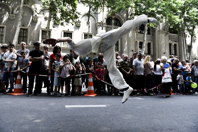 An acrobat entertains the crowd in Tbilisi, Georgia during celebrations marking the 100th anniversary of the foundation of the first Georgian democratic state on May 26, 2018. (Photo by Mzia Seganelidze/RFE/RL)
