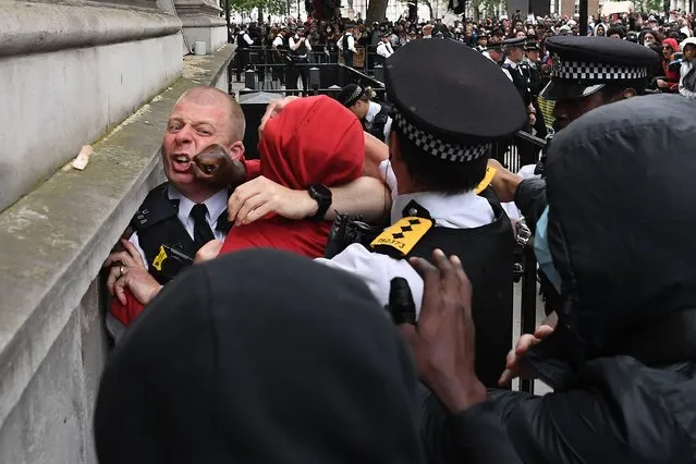 Police officers react as they attempt to detain a protestor near the entrance to Downing Street, during an anti-racism demonstration in London, on June 3, 2020, after George Floyd, an unarmed black man died after a police officer knelt on his neck during an arrest in Minneapolis, USA. Londoners defied coronavirus restrictions and rallied on Wednesday in solidarity with protests raging across the United States over the death of George Floyd, an unarmed black man who died during an arrest on May 25. (Photo by Daniel Leal-Olivas/AFP Photo)