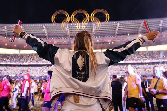 A athlete from Team France gestures as the Olympic Rings are seen in the background during the Closing Ceremony of the Olympic Games Paris 2024 at Stade de France on August 11, 2024 in Paris, France. (Photo by Carl Recine/Getty Images)