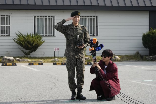 K-pop band BTS member J-Hope, center, salutes as fellow member Jin holds microphones after being discharged from a mandatory military service outside of an army base in Wonju, South Korea, Thursday, October 17, 2024. (Photo by Ahn Young-joon/AP Photo)