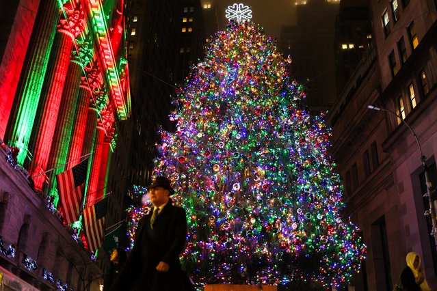 People walks past the Christmas tree displayed outside the New York Stock Exchange (NYSE) on December 16, 2024. (Photo by Charly Triballeau/AFP Photo)