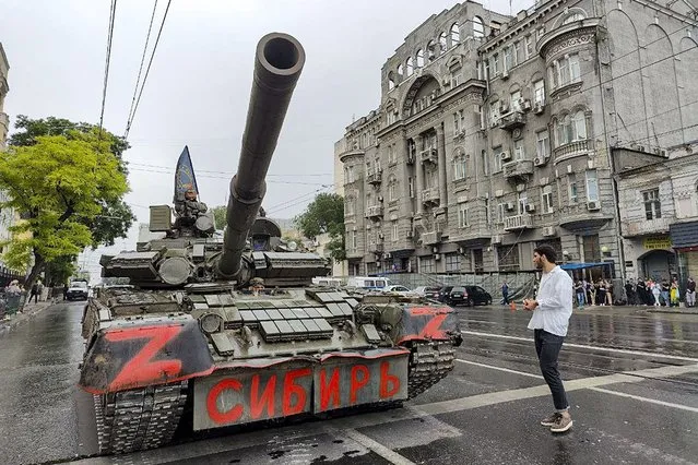 Servicemen sit in a tank with a flag of the Wagner Group military company and writing reading "Siberia", as they guard an area at the HQ of the Southern Military District in a street in Rostov-on-Don, Russia, Saturday, June 24, 2023. Russia's security services had responded to Prigozhin's declaration of an armed rebellion by calling for his arrest. In a sign of how seriously the Kremlin took the threat, security was heightened in Moscow, Rostov-on-Don and other regions. (Photo by AP Photo/Stringer)