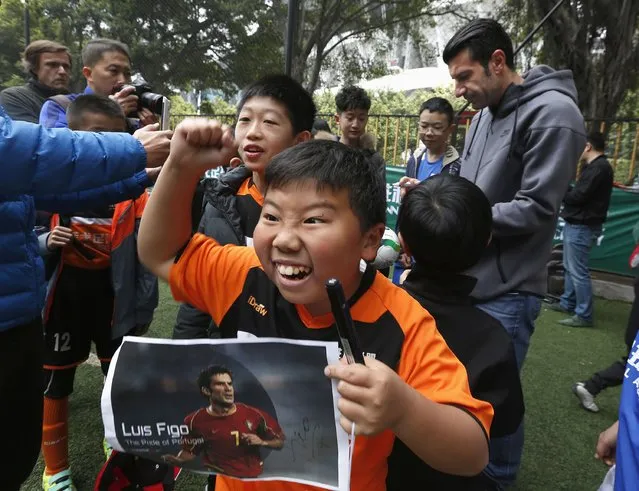 A boy reacts after getting an autograph from former Portugal forward Luis Figo (back R) during a Figo Football Academy training session in the southern Chinese city of Guangzhou February 4, 2015. FIFA have confirmed that incumbent Sepp Blatter, Figo, Dutch FA president Michael van Praag and Prince Ali Bin Al-Hussein of Jordan have bid to stand for president. (Photo by Bobby Yip/Reuters)