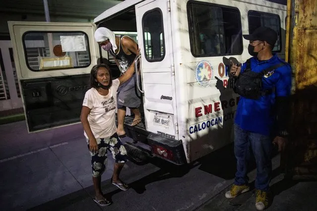 Curfew violators are brought to a holding area as the government implements a curfew in the country's capital amid rising coronavirus disease (COVID-19) cases, in Caloocan City, Metro Manila, Philippines, March 17, 2021. (Photo by Eloisa Lopez/Reuters)