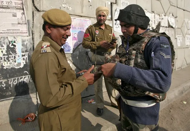 An Indian Air Force soldier (R) checks the identity card of a policeman outside the Indian Air Force (IAF) base at Pathankot in Punjab, India, January 3, 2016. Gunfire and blasts were heard on Sunday at the Indian Air Force base attacked by militants a day earlier, as security forces hunted two gunmen still at large in the sprawling facility near the border with Pakistan. (Photo by Mukesh Gupta/Reuters)