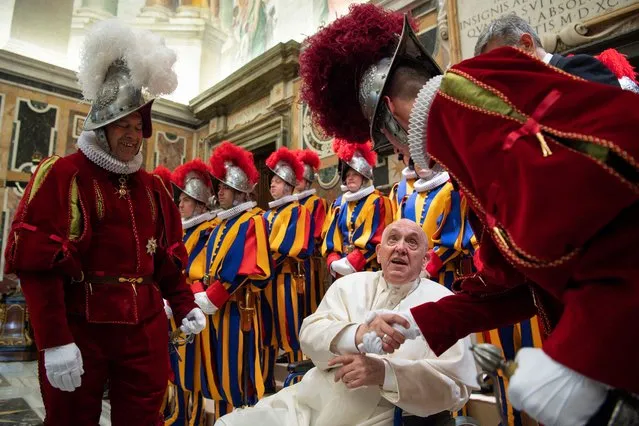 This photo taken and handout on May 6, 2022 by The Vatican Media shows Pope Francis, seated in a wheelchair following knee treatment, greeting Swiss Guards within the swearing-in ceremony of new recruits of the pontifical Swiss guard in The Vatican. (Photo by Handout/Vatican Media via AFP Photo)