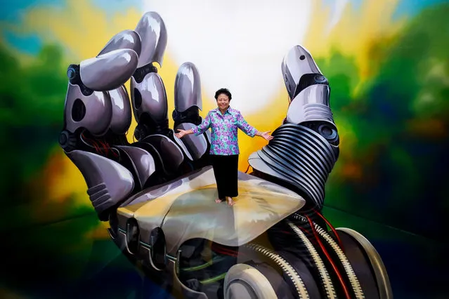 A visitor interacts with a 3D painting at the Art in Paradise museum in Bangkok, Thailand, 10 September 2018. Set up in two floors and comprising six permanent zones, Art in Paradise Bangkok is the first 3D and “Illusion” museum in Thailand's capital, featuring 150 paintings for visitors to experience a unique form of art appreciation by interacting with the art pieces. In contrast to most museums, Art In Paradise not only allows photographing the museum's paintings, but it actually encourages visitors to do so. And in order to protect the paintings which cover the floors, walls and ceilings, guests must remove their shoes. It took 15 Korean and Thai artists two and a half months to complete the paintings. (Photo by Diego Azubel/EPA/EFE)