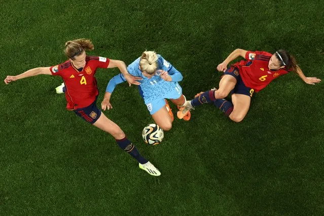 England's forward #11 Lauren Hemp (C) is tackled by Spain's defender #04 Irene Paredes (L) and Spain's midfielder #06 Aitana Bonmati (R) during the Australia and New Zealand 2023 Women's World Cup final football match between Spain and England at Stadium Australia in Sydney on August 20, 2023. (Photo by David Gray/AFP Photo)