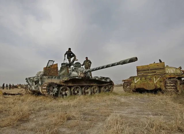 Members of Afghan security force inspect destroyed Soviet military tank at a junkyard in Jalalabad province, February 15, 2015. (Photo by Reuters/Parwiz)