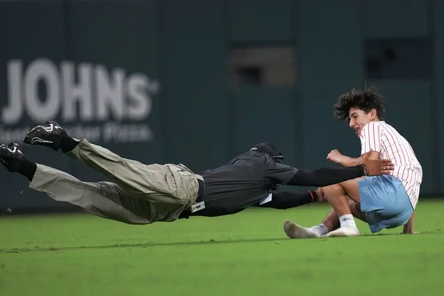 A fan who ran on to the field is tackled by a Truist Park security guard in the eight inning of a baseball game between St. Louis Cardinals and Atlanta Braves, Tuesday, September 5, 2023, in Atlanta. (Photo by John Bazemore/AP Photo)