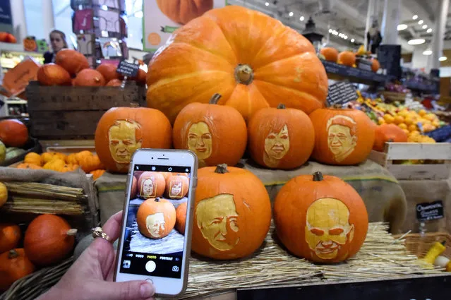 A woman takes a picture on her phone of Halloween pumpkins with Ireland's Presidential candidates faces carved into them in a shop ahead of an upcoming Presidential election in Dublin, Ireland October 15, 2018. (Photo by Clodagh Kilcoyne/Reuters)