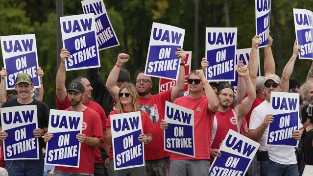 United Auto Workers members hold picket signs near a General Motors Assembly Plant in Delta Township, Mich., Friday, September 29, 2023. (Photo by Paul Sancya/AP Photo)