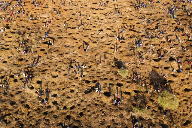 An aerial view shows people digging as they search for what they believe to be diamonds after the discovery of unidentified stones at KwaHlathi village near Ladysmith in KwaZulu Natal on June 15, 2021. Hundreds of people have flocked to the outskirts of KwaHlathi village, near Ladysmith, after a cattle herder last week unearthed a handful of unidentified crystal-like pebbles. News of the finding spread fast, triggering a rush to the site. Some have already started selling their finds to those willing to try to market them. Experts do not rule out the possibility that they are genuine diamonds, although they consider this highly unlikely. The Department of Energy and Mines said it would send a team of experts in the next few days. (Photo by Phill Magakoe/AFP Photo)
