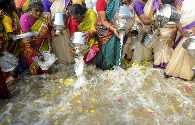 Indian women pours milk into the sea as an offering during a ceremony for the victims of the 2004 tsunami at Marina Beach in Chennai on December 26, 2016 The earthquake and tsunami that struck the Indian Ocean on December 26, 2004 killed over 230,000 people and devastated coastal communities, including the shorelines of the southern Indian states of Tamil Nadu, Andhra Pradesh, and Kerala. (Photo by Arun Sankar/AFP Photo)