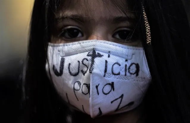 A girl wears a mask with the phrase “Justice for Luz”, written on it in Spanish, during a protest by feminist groups for Luz Raquel Padilla, in front of the Jalisco state government House in Mexico City, Thursday, July 21, 2022. Luz Raquel Padilla, the mother of a child with autism, was doused with alcohol and burned alive by a group of people a few blocks from her home on July 16 in Jalisco state. She died of her wounds. (Photo by Marco Ugarte/AP Photo)