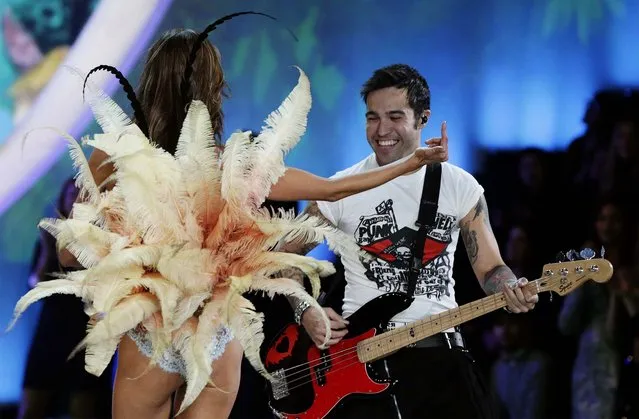 Alessandra Ambrosio gestures to the crowd as she walks by guitarist Pete Wentz while presenting a creation during the Victoria's Secret Fashion Show. (Photo by Lucas Jackson/Reuters)
