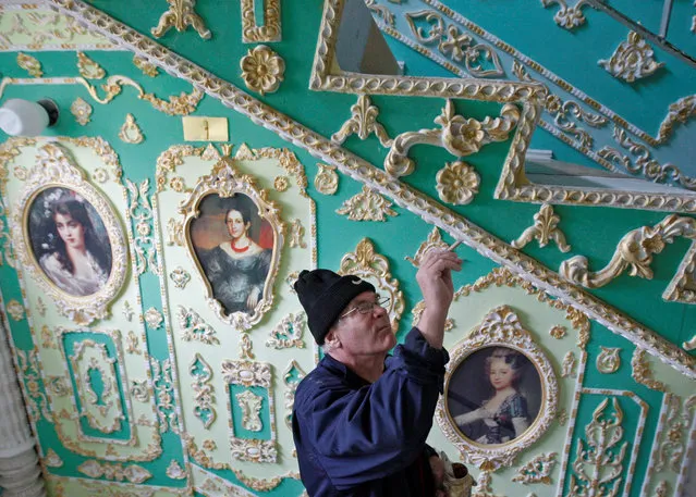 65-years-old Ukrainian pensioner Volodymyr Chaika is seen in a stairwell of an apartment block which is decorated by him in old fashioned style in Kiev, Ukraine, on December 29, 2016. Former subway worker Volodymyr Chaika using plaster, paint, wallpapers and art reproductions, over the past 15 years decorating three floors of an apartment block as in a palace style. (Photo by Vladimir Shtanko/Anadolu Agency/Getty Images)