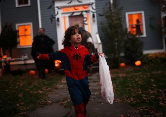 A child in Halloween costume goes trick or treating in the New York City suburb of Upper Nyack, New York, U.S., October 31, 2023. (Photo by Mike Segar/Reuters)