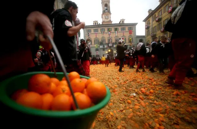 A member of a rival team carries oranges during an annual carnival battle in the northern Italian town of Ivrea February 7, 2016. (Photo by Stefano Rellandini/Reuters)